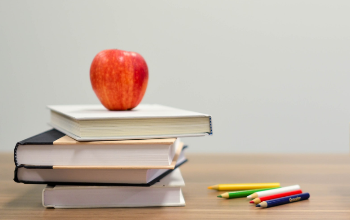 Apple on books with colored pencils