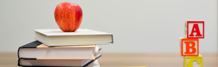 Apple on top of books with ABC blocks